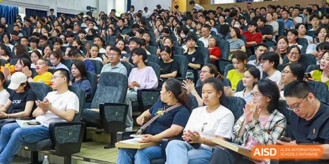 Students from Xi'an Jiaotong-Liverpool University Affiliated School (XJTLU-AS) attending a lecture or presentation in a crowded auditorium.