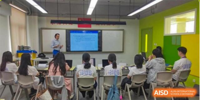Students looking towards the front of a classroom where a presentation is displayed on a screen at Wuxi No.1 High School.