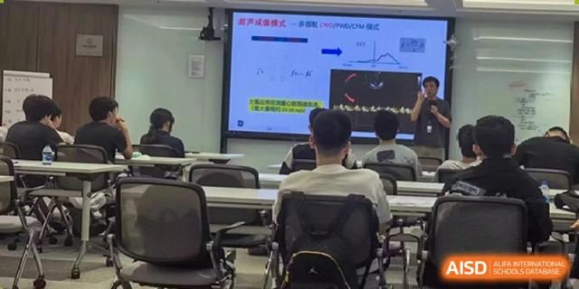A student viewing a presentation with graphs projected onto a large digital screen during a class at Wuxi No.1 High School.