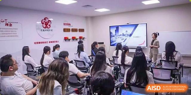 A group of students seated in a modern classroom or lab space with multiple screens visible during a lesson at Wuxi No.1 High School.