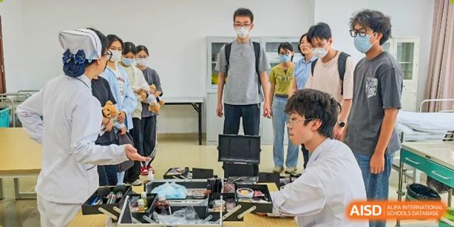 A group of students working on a hands-on project with laptops and various equipment in a technical classroom or lab at Wuxi No.1 High School.