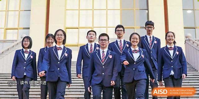 A group of students smiling and posing in their formal school uniforms at Wuxi No.1 High School.