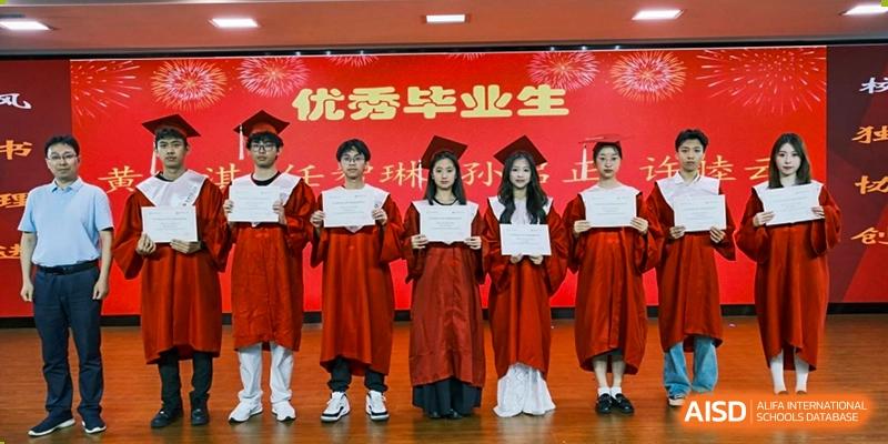 A group of graduating students wearing red gowns and holding diplomas on a stage with a banner that reads "Excellent Graduates" at Wuxi No.1 High School.