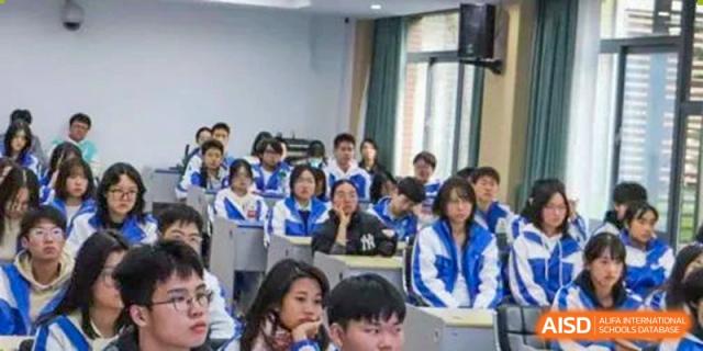 A group of students in blue and white uniforms sitting at their desks in a classroom. Chengdu Shishi Tianfu High School International Department.