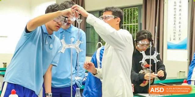 A teacher pointing to a beaker while explaining a scientific concept to students in a lab. Chengdu Shishi Tianfu High School International Department.