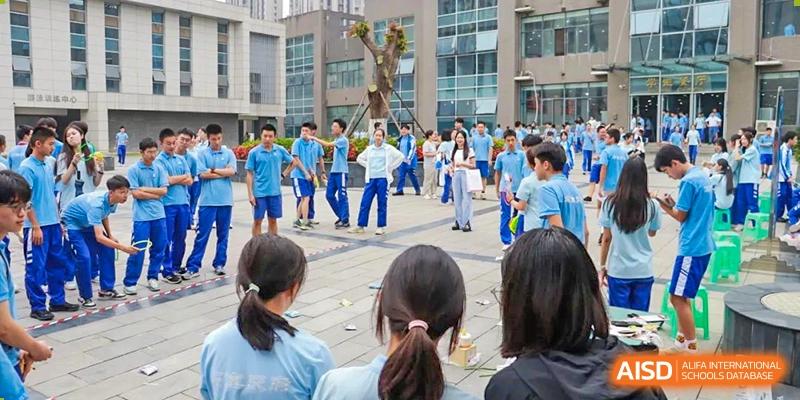 A group of students in blue and white uniforms at an outdoor school event. Chengdu Shishi Tianfu High School International Department.