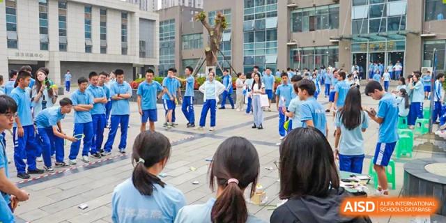 A group of students in blue and white uniforms at an outdoor school event. Chengdu Shishi Tianfu High School International Department.