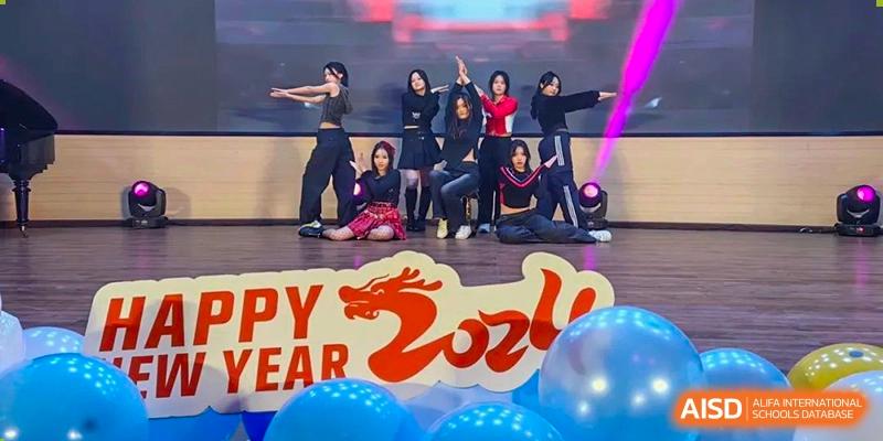 A group of students performing a synchronized dance on a stage with a banner that says "Happy New Year 2024". Chengdu Shishi Tianfu High School International Department.