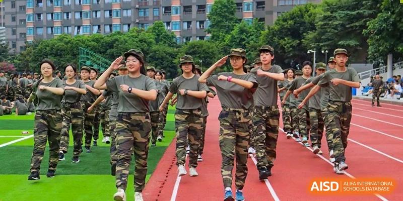 A line of students in camouflage military training uniforms marching on a track. Chengdu Shishi Tianfu High School International Department.
