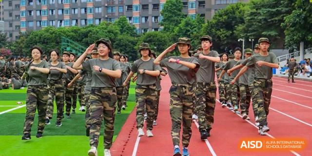 A line of students in camouflage military training uniforms marching on a track. Chengdu Shishi Tianfu High School International Department.