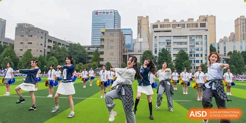 A group of students in casual clothes running and cheering on a sports field. Chengdu Shishi Tianfu High School International Department.