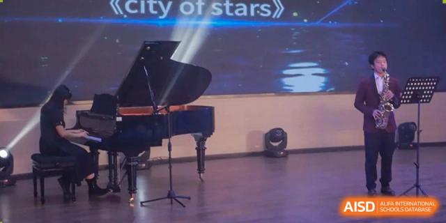 A grand piano on a stage in front of a digital backdrop. Chengdu Shishi Tianfu High School International Department.