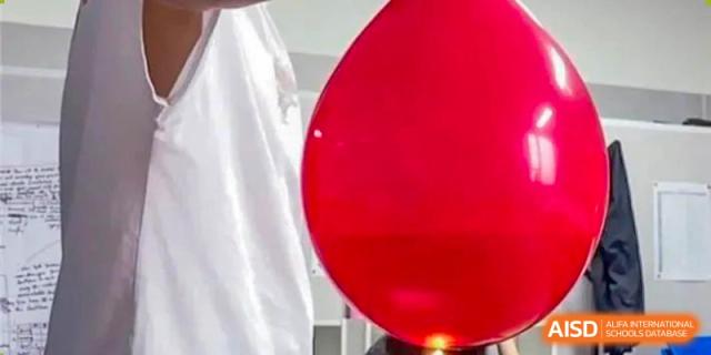 A close-up shot of a red balloon in a science experiment at BaiShan AWS High School.