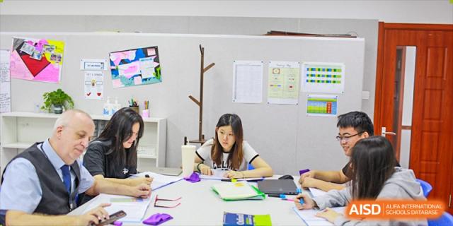 A student sitting at a desk and studying at BaiShan AWS High School.
