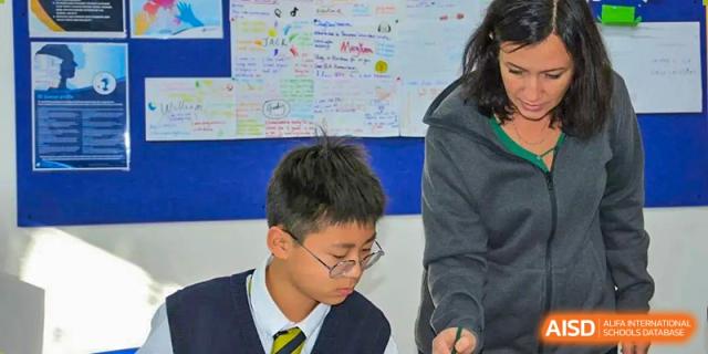A close-up shot of a BaiShan AWS High School student concentrating and taking notes during class.