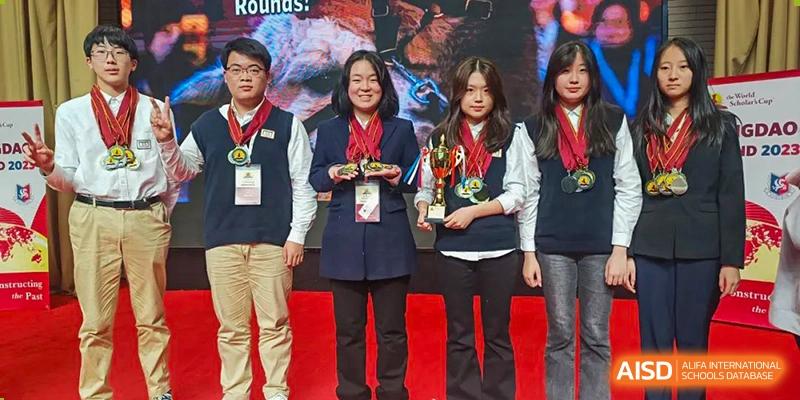 Students proudly holding trophies and medals at a BaiShan AWS High School awards ceremony.