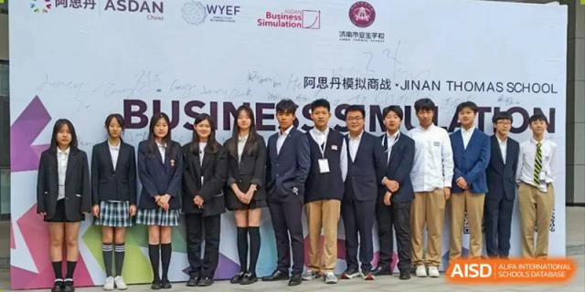 A group of young men and women in suits standing together for a photo at a BaiShan AWS High School event.