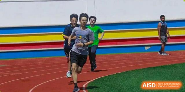Students running during a sports activity or race at BaiShan AWS High School.