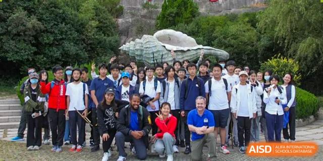 A group of students and a teacher, possibly on a field trip or school outing, at a BaiShan AWS High School event.