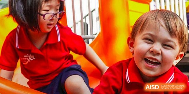 A student is sliding down an orange slide at Chengdu International School.