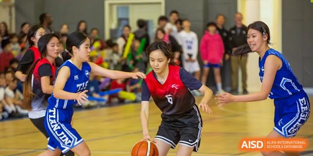 A student from Chengdu International School dribbles a basketball during a game.
