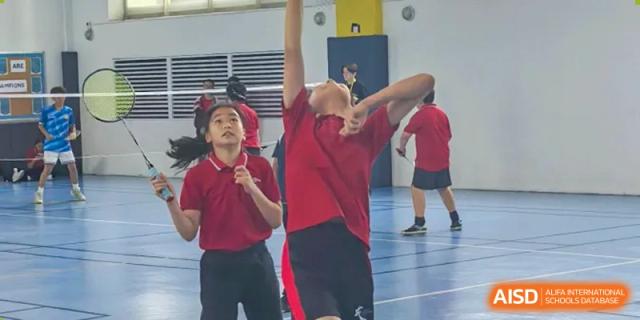 A student from Chengdu International School jumps to block a shot during a volleyball game.