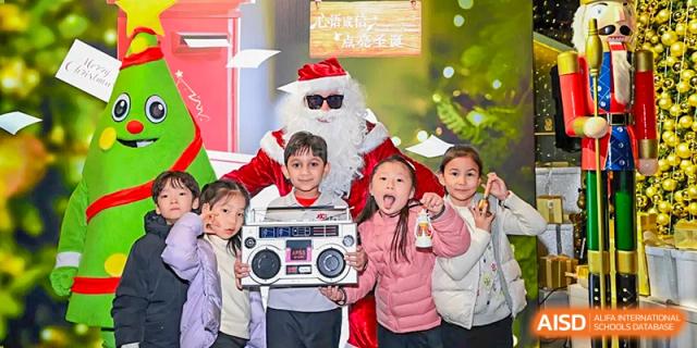Young children are smiling and holding a boombox while posing with Santa at Chengdu International School.