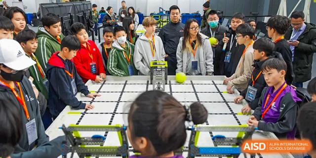 Students and teachers are watching a robotic competition from a distance at Chengdu International School.