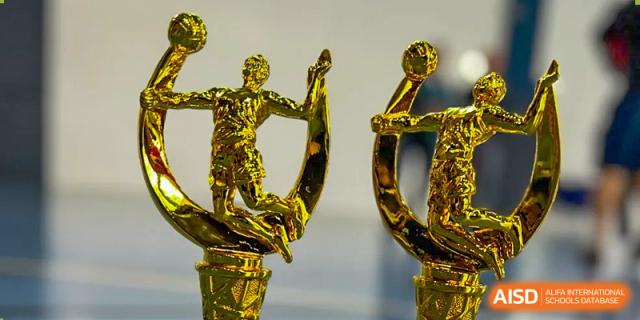 Three golden trophies are sitting on a table at Chengdu International School.