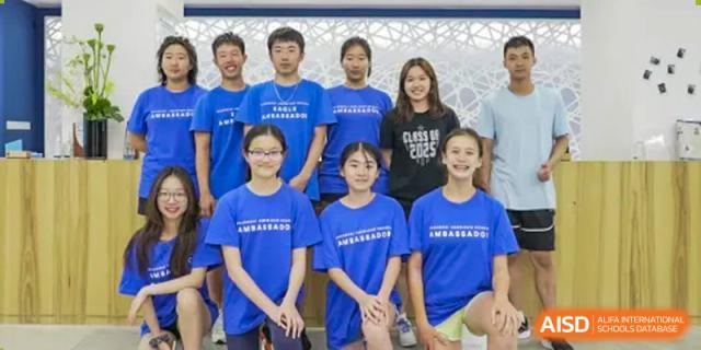 A group of students from Shanghai American School are posing together, wearing blue shirts.