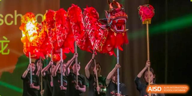 A group of students from Shanghai American School are performing a traditional dragon dance.