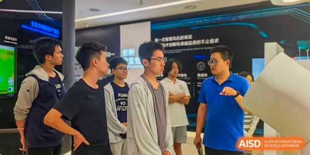 A group of male students standing and listening at an indoor event or presentation, Beijing Etown Academy International Department