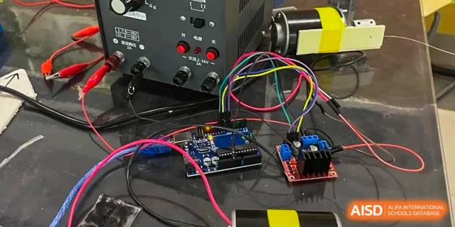 Close-up of a microcontroller board and colored wires connected to an electronic power supply, likely for a robotics project, Beijing Etown Academy International Department