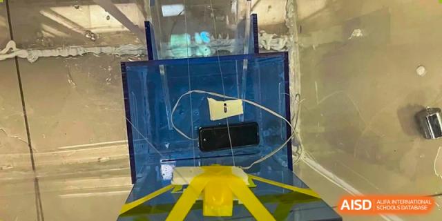 An experimental or engineering project contained within a blue transparent plastic box or enclosure, Beijing Etown Academy International Department