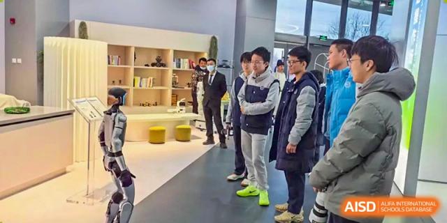 A line of male students and faculty members standing in a modern, brightly lit indoor hall or lobby, Beijing Etown Academy International Department