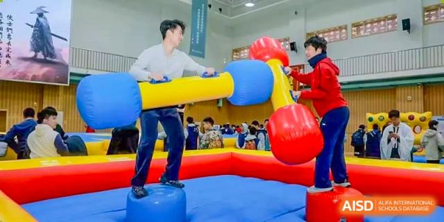 People on a blue and red inflatable obstacle course or game at an event, Beijing Etown Academy International Department