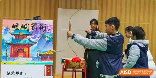 Student aiming a bow and arrow during an archery activity with a target nearby, Beijing Etown Academy International Department