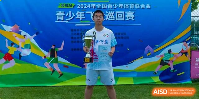 Student athlete holding a large trophy and certificate after winning a sports competition, Beijing Etown Academy International Department