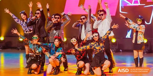 A group of Cogdel Cranleigh School Changsha students posing dramatically on stage in vibrant costumes for a theatrical or musical performance.