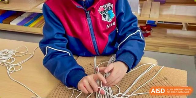 Close-up of an AISB-Hope International student's hands working on a weaving or craft project.