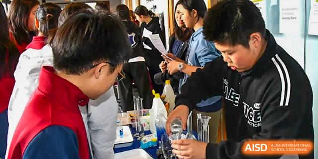 AISB-Hope International students conducting a science experiment using beakers and lab equipment.