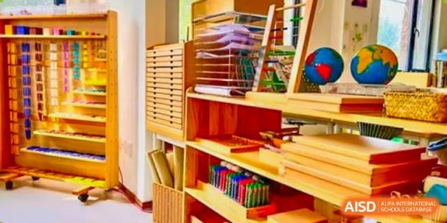 A neatly organized classroom shelf at AISB-Hope International stocked with academic materials and supplies.