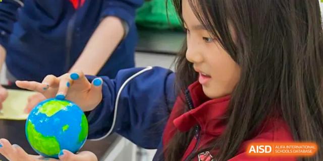 Close-up of a smiling AISB-Hope International student engaged in a hands-on learning activity or social interaction.