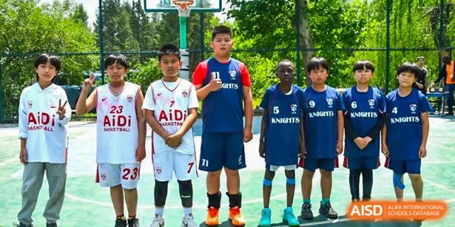 Three male students from AISB-Hope International standing in uniform on an outdoor court, possibly representing two different teams.