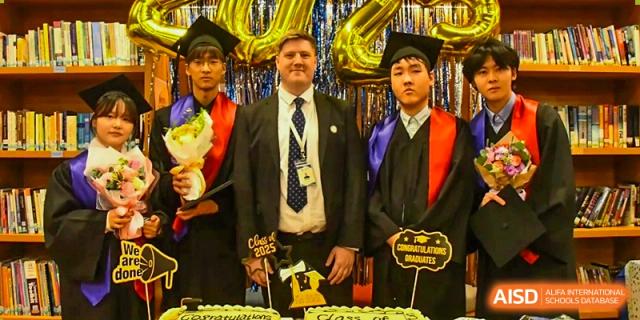 A teacher and two graduating students from AISB-Hope International posing for a photo at a graduation ceremony.