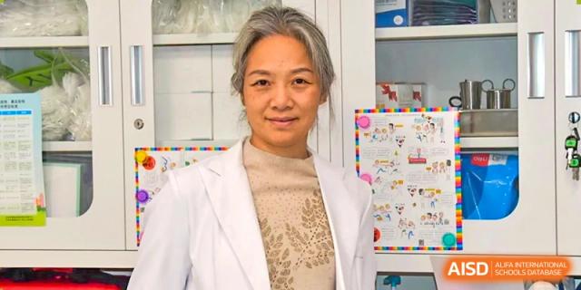 A female staff member or health professional at AISB-Hope International wearing a white lab coat.