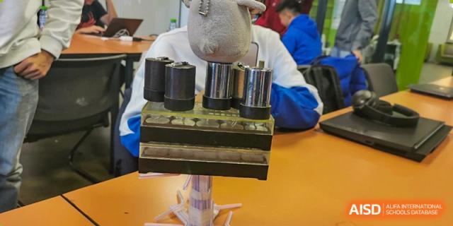 A close-up view of science or engineering apparatus on a student's desk at The Affiliated High School of Peking University's Dalton Academy, likely for a physics or mechanics project.