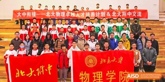 A large group of students and teachers from The Affiliated High School of Peking University's Dalton Academy posing for a photo, holding a red banner with Chinese text related to Physics.