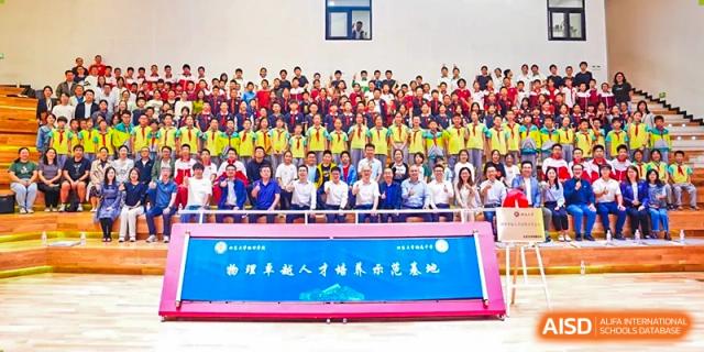 A large number of students from The Affiliated High School of Peking University's Dalton Academy posing for a group photograph in an auditorium setting.