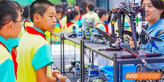 Students from The Affiliated High School of Peking University's Dalton Academy participating in a hands-on robotics or engineering activity in a workshop setting.
